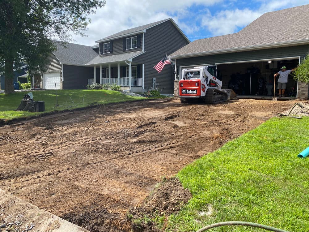 Bobcat machine working on a residential property, preparing land for landscaping.